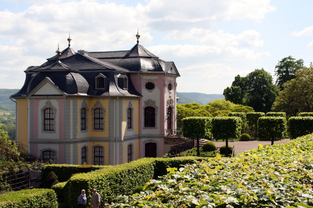 a large pink and white building surrounded by hedges