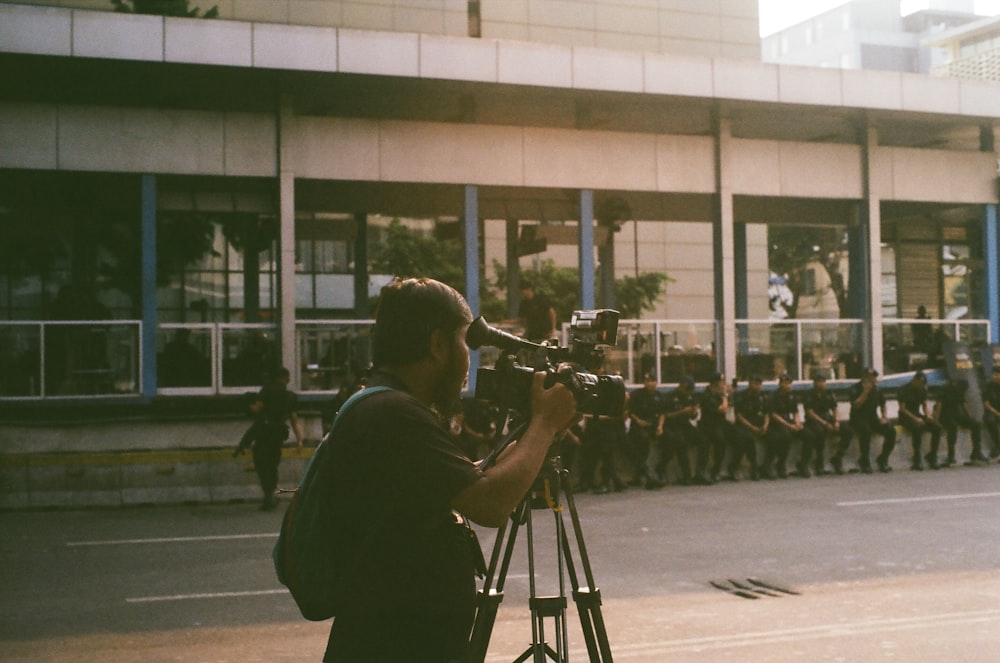 a man standing in front of a camera on a street