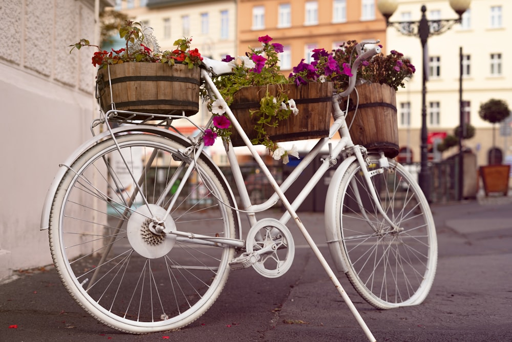 a white bicycle with a basket full of flowers