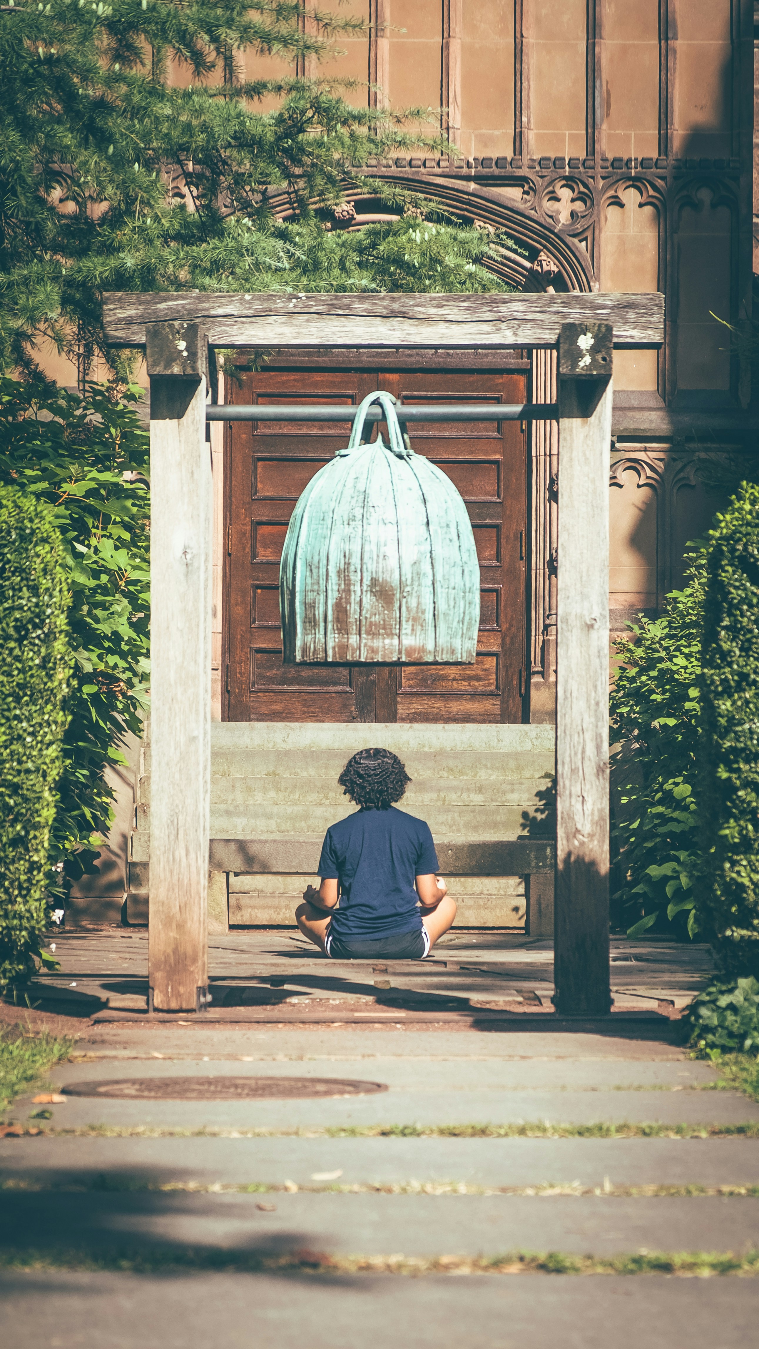 Una persona sentada en un banco frente a un edificio