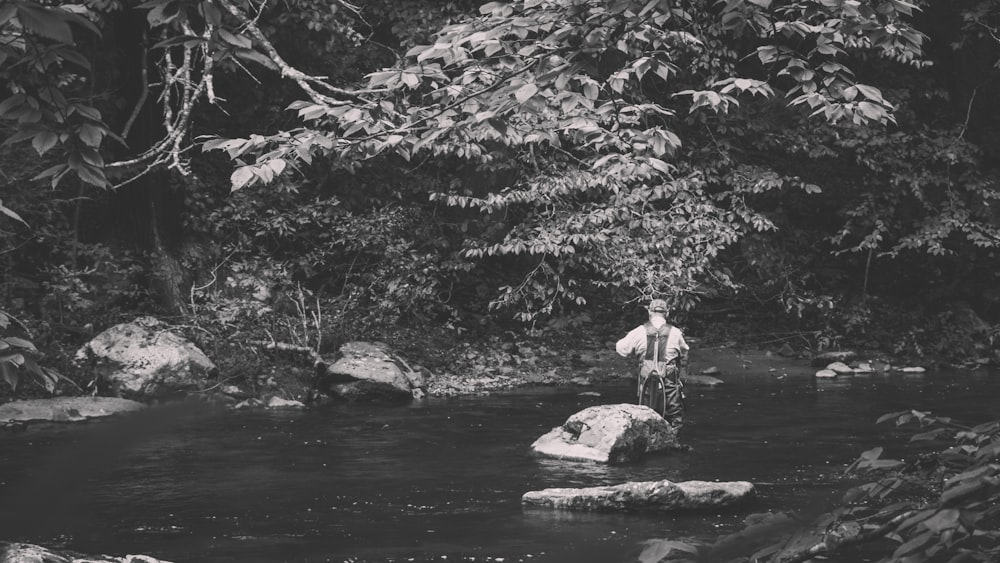 a man standing on a rock in a river