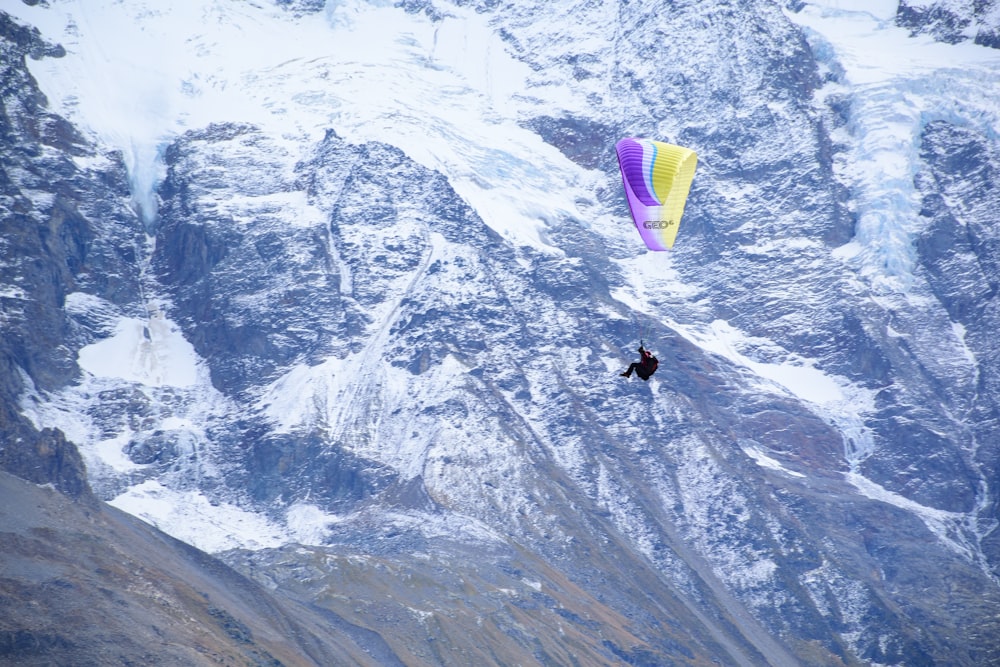 une personne fait du parachute ascensionnel dans les montagnes