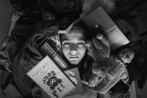 a boy holding a teddy bear and a book