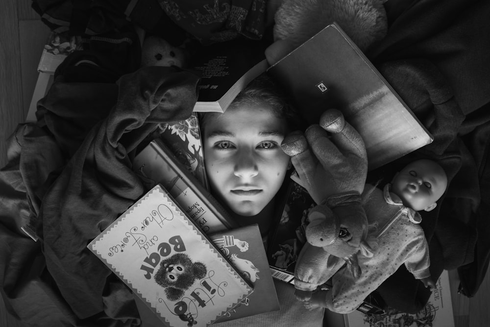 a boy holding a teddy bear and a book