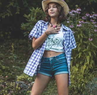 a woman in shorts and a hat posing for a picture