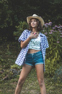 a woman in shorts and a hat posing for a picture