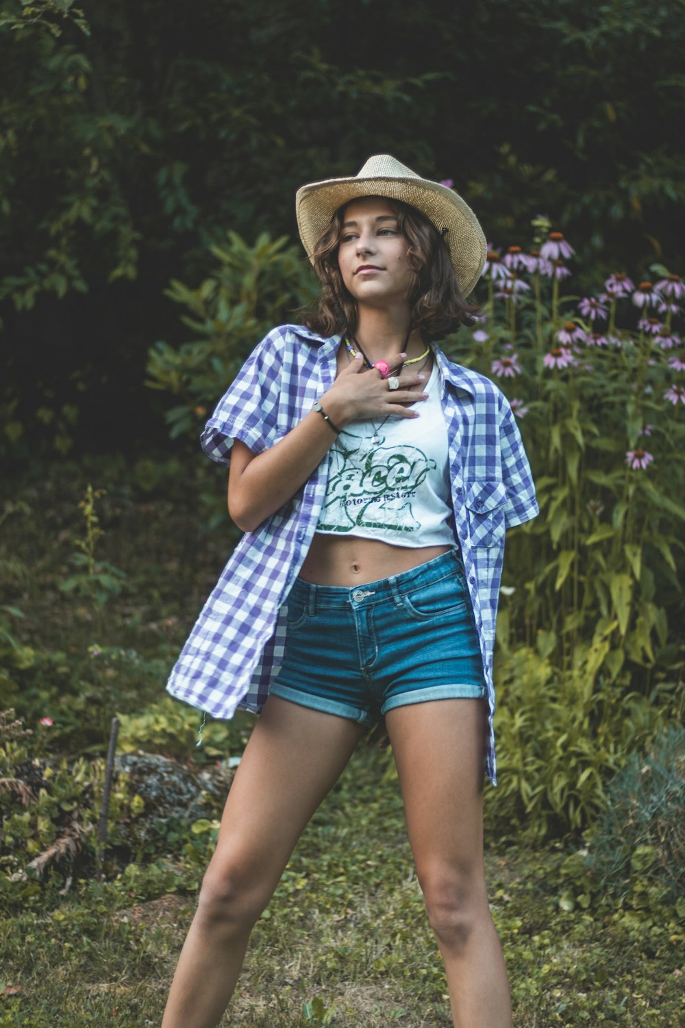 Una donna in pantaloncini corti e un cappello in posa per una foto