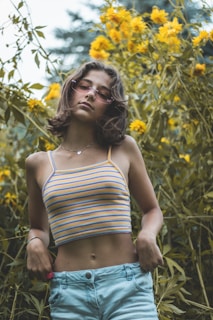 a woman standing in front of a field of flowers