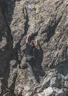 a man climbing up the side of a mountain