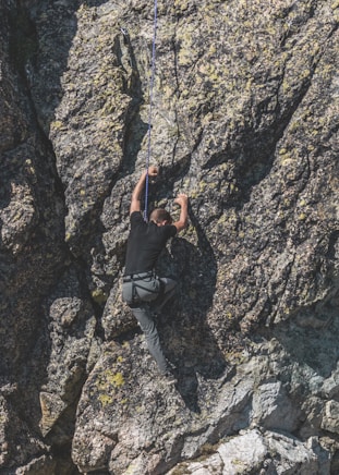 a man climbing up the side of a mountain