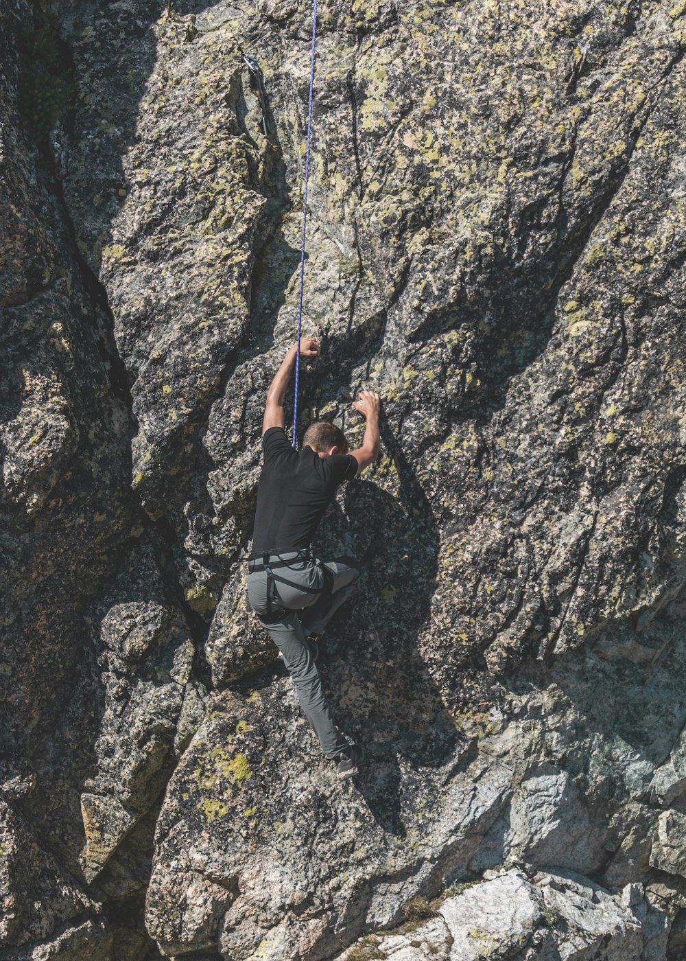 Un hombre trepando por la ladera de una montaña