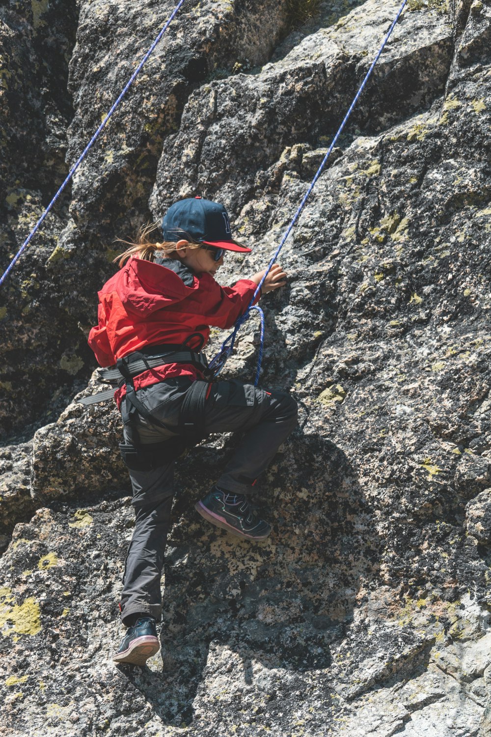 a person climbing up a mountain with a rope