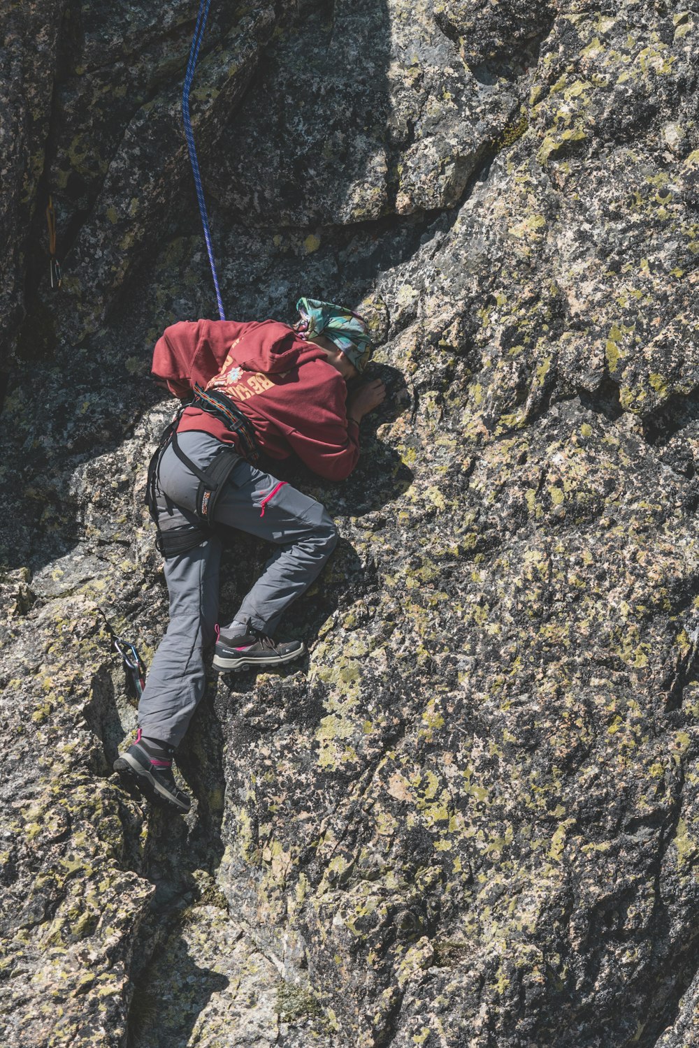 Un homme grimpant sur le flanc d’une montagne