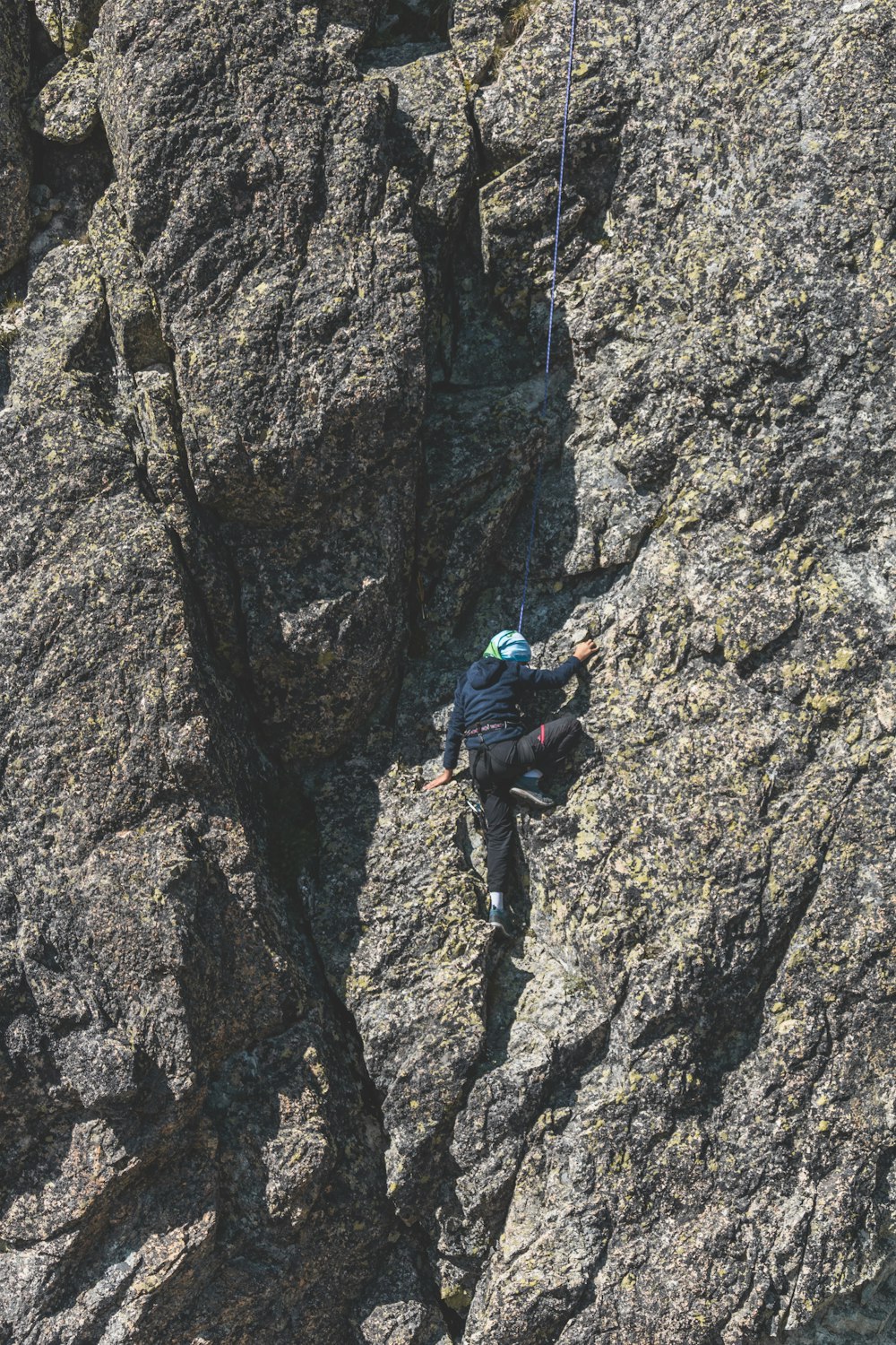 Un homme grimpant sur le flanc d’une montagne