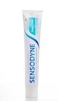 A tube of Sensodyne Deep Clean toothpaste is standing upright against a white background. The design is characterized by a dominant blue color with the brand name 'SENSODYNE' in bold letters and a smaller label indicating 'Deep Clean'. The tube features a small orange circle with 'gsk' written in it, indicating the brand affiliation.