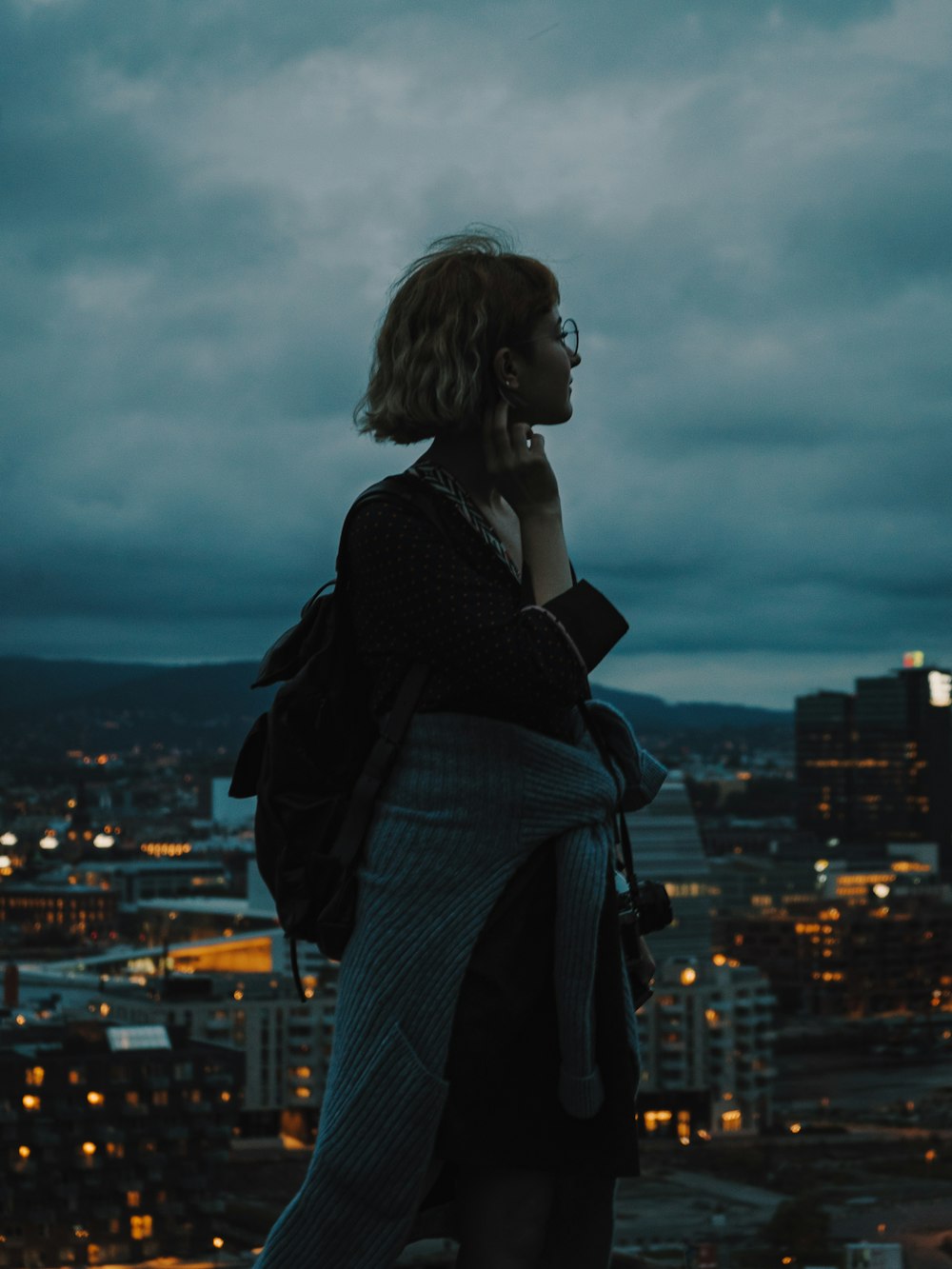 a woman standing on top of a building while talking on a cell phone