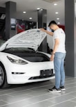a man looking under the hood of a car