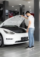 a man looking under the hood of a car