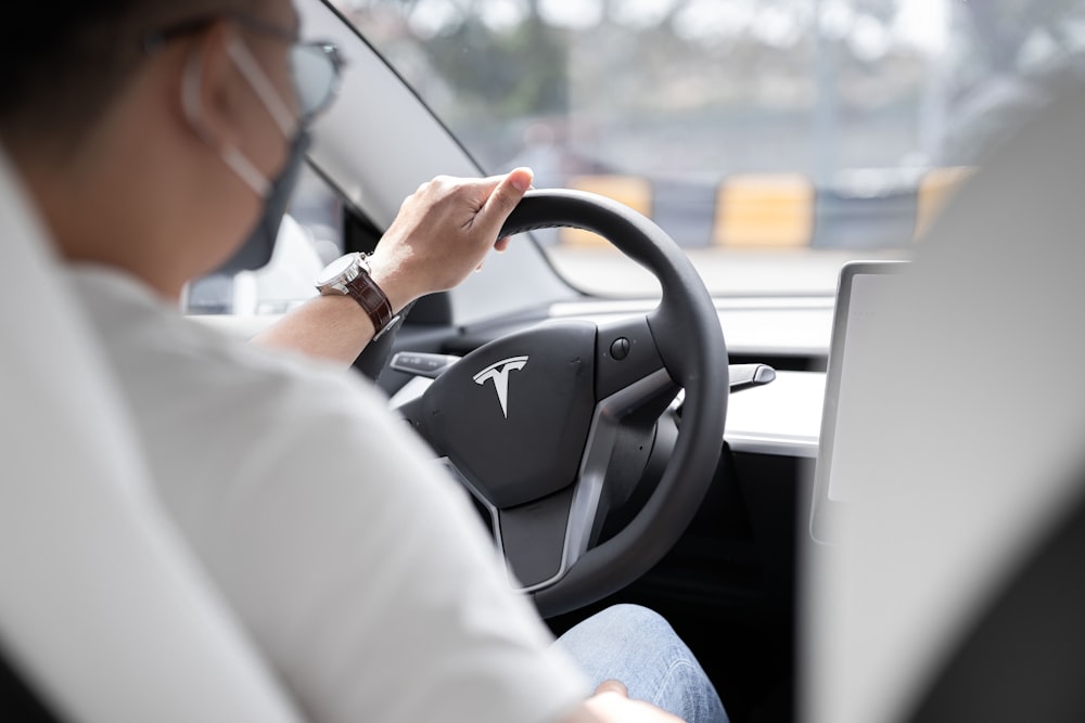 a person sitting in a car with a laptop