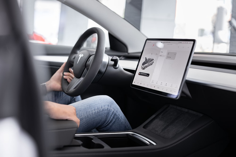 a person sitting in a car with a tablet