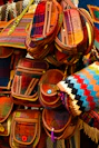 Close-up of colorful handmade fabric bags arranged neatly on a wooden table
