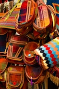 A collection of colorful handmade bags arranged artfully on a wooden shelf