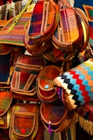 A collection of colorful handmade bags displayed on a rustic shelf