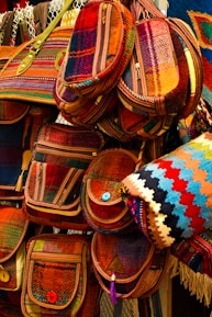 A collection of colorful handmade bags displayed on a wooden table.