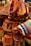A collection of colorful, woven bags with intricate patterns, featuring various shades of red, orange, and blue. The bags have button closures and are arranged in a layered display, giving a vibrant and artistic impression.
