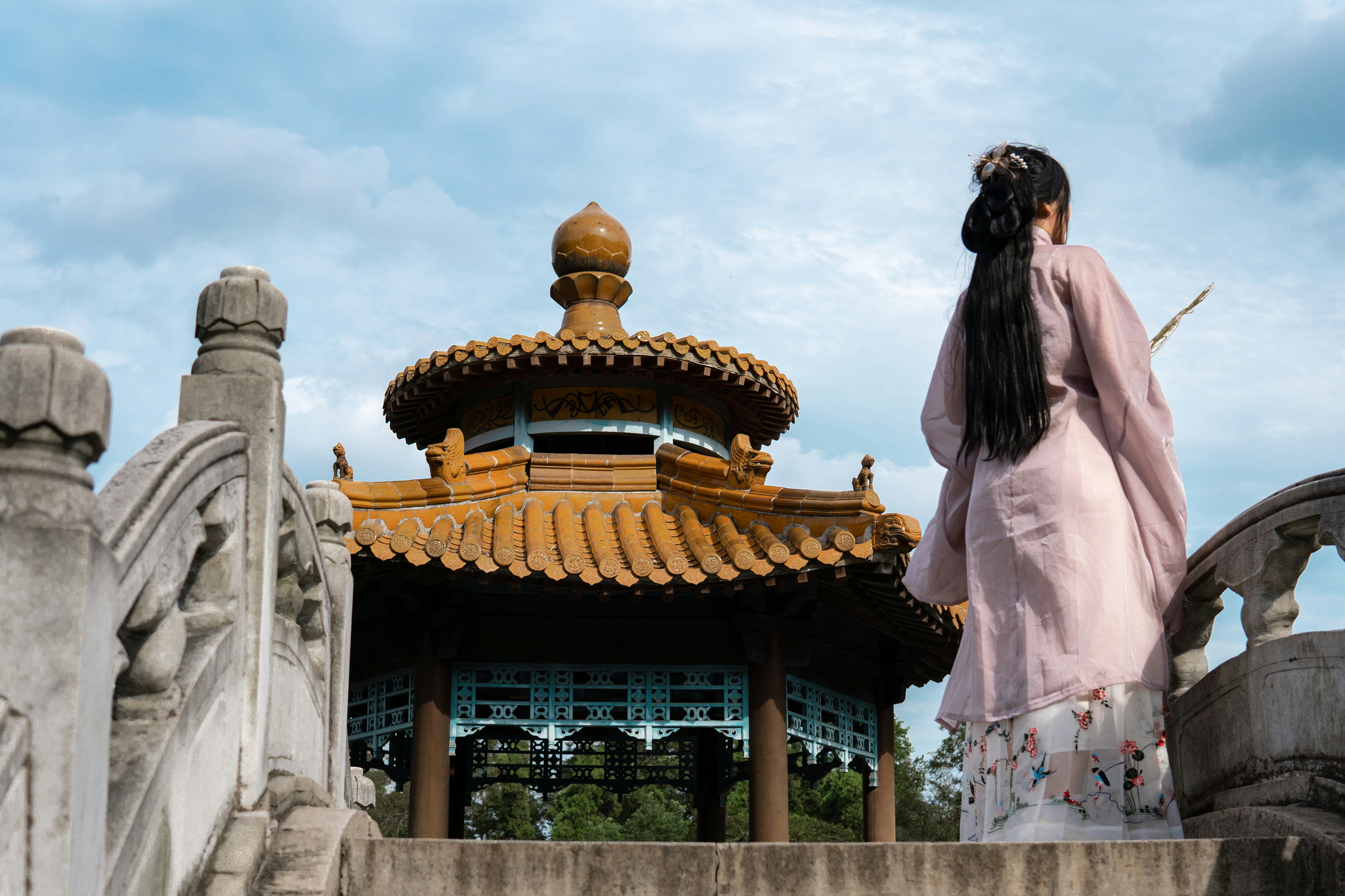 Una mujer con un vestido rosa parada frente a un edificio