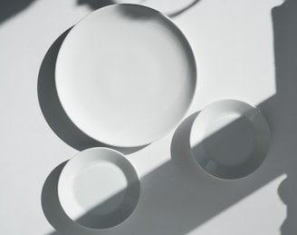 a white plate and two white bowls on a table