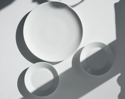a white plate and two white bowls on a table