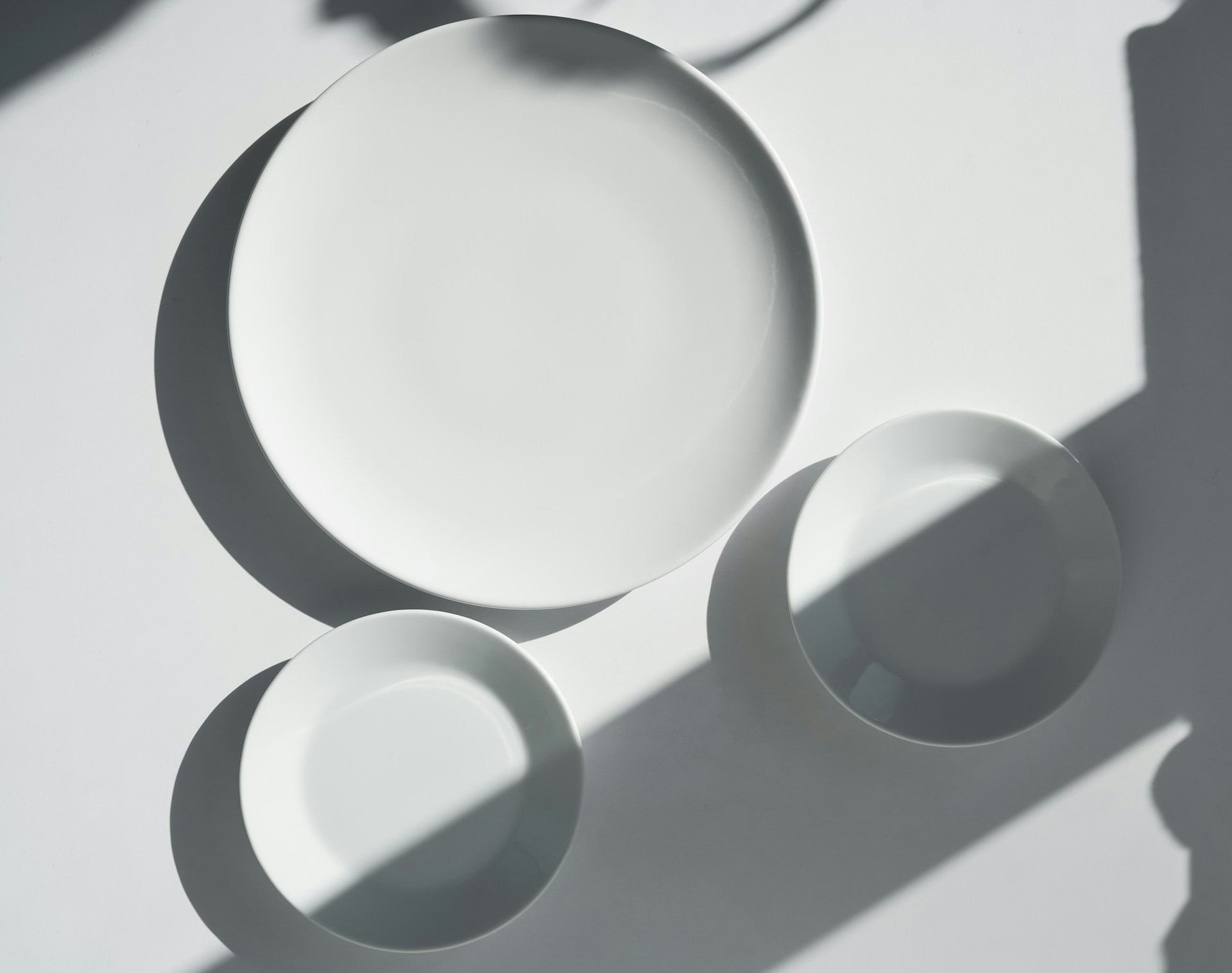 a white plate and two white bowls on a table