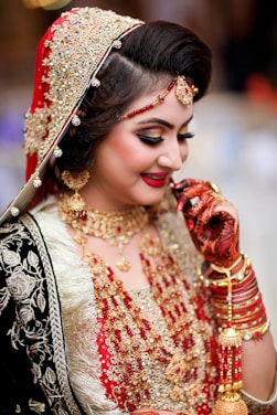 a woman in a red and gold bridal outfit