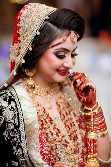a woman in a red and gold bridal outfit