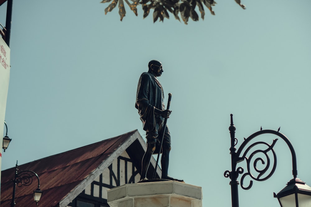 uma estátua de um homem em pé no topo de um edifício