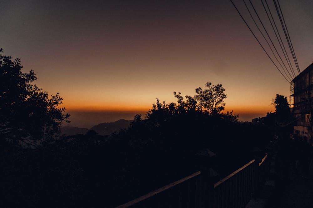 the sun is setting over the mountains and trees