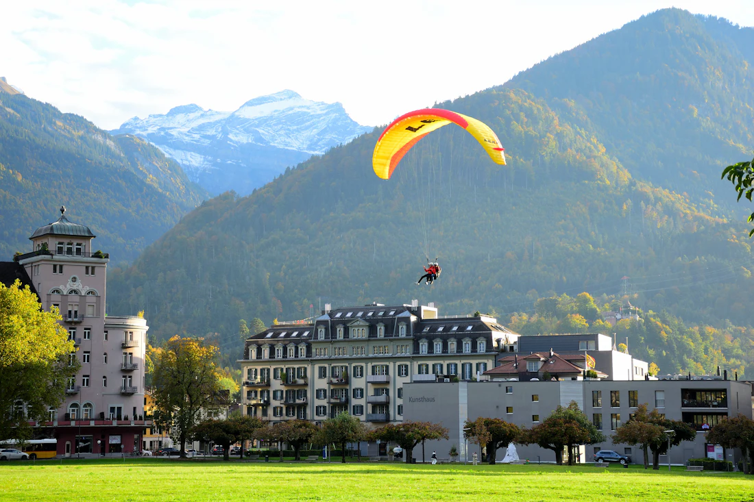 Paraglider boven Interlaken met bergen op de achtergrond (herfstopname)