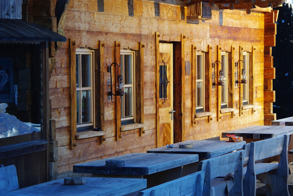 a row of wooden benches sitting in front of a building