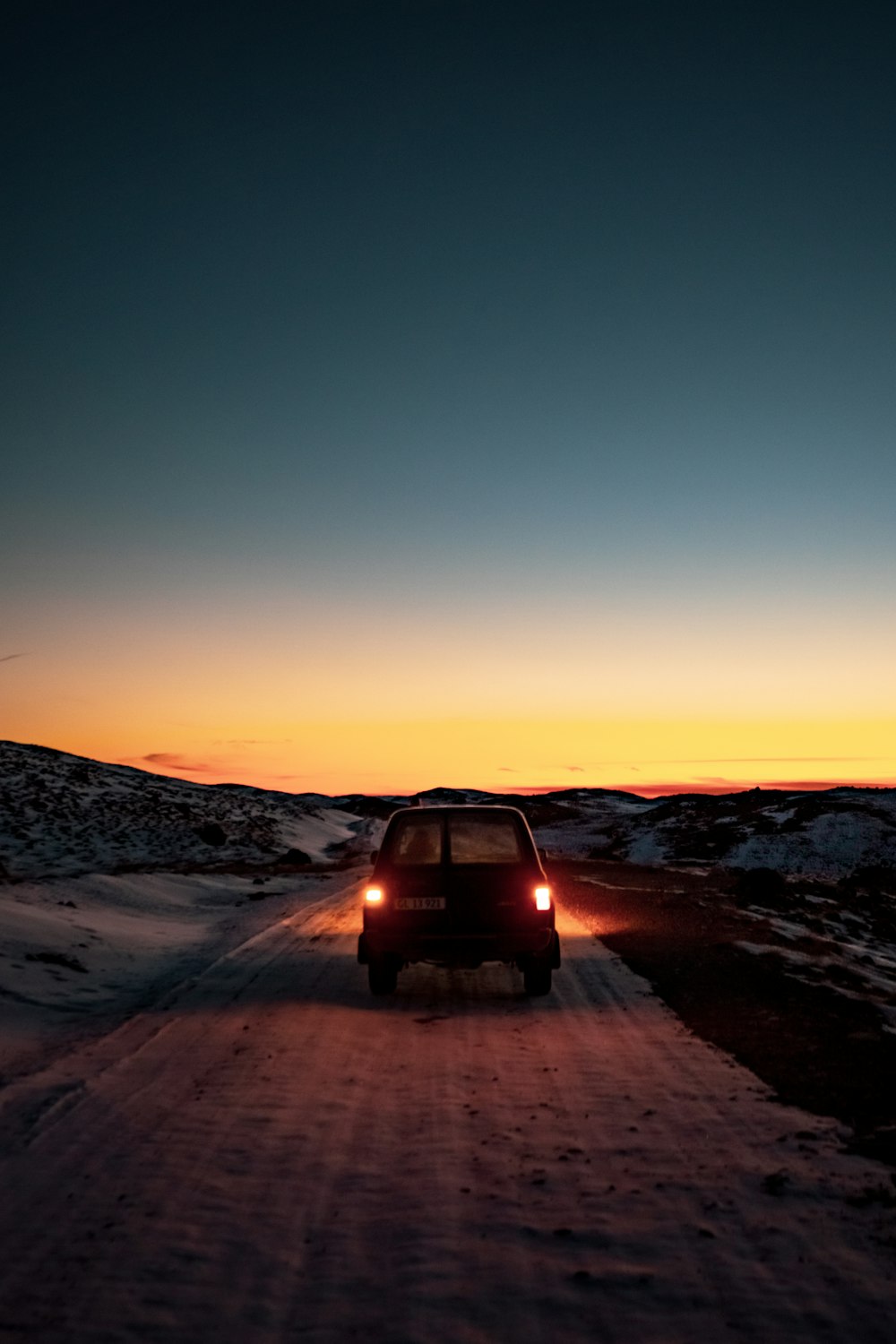 a car driving down a snow covered road