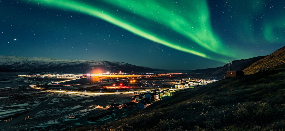 a green aurora bore above a city at night