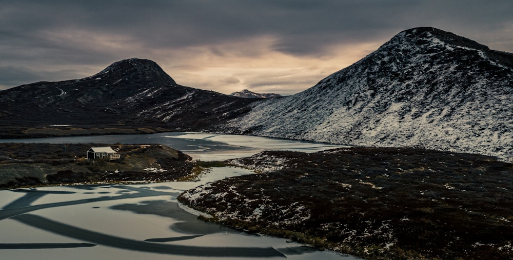 a snow covered mountain with a body of water in the foreground