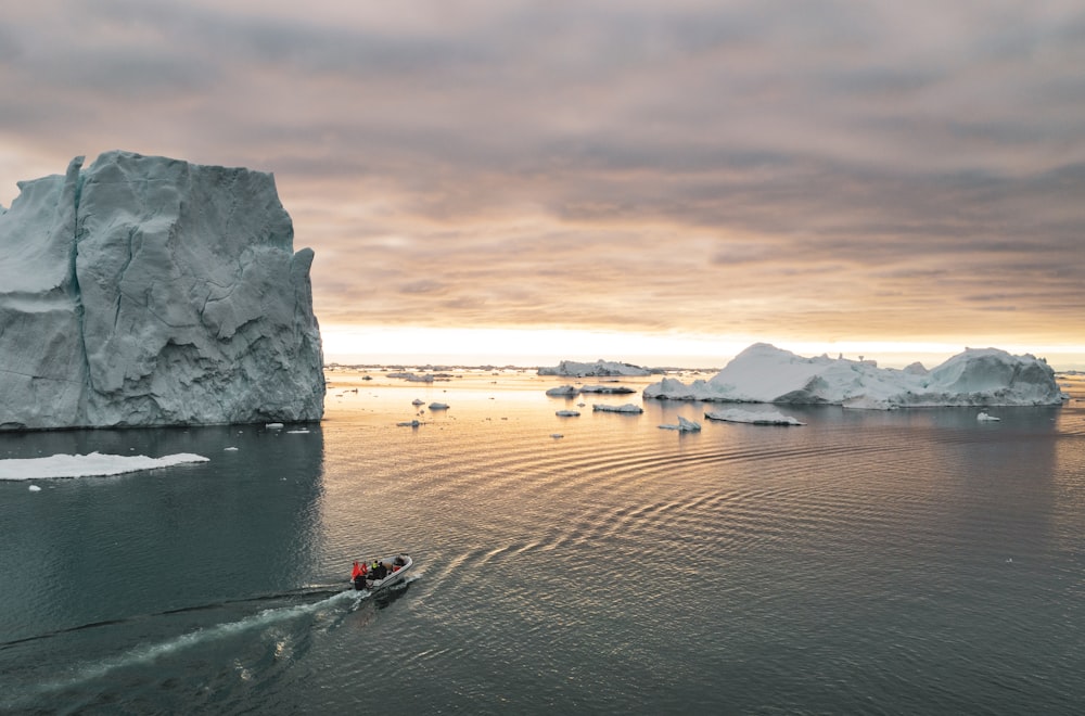 a boat in a body of water with icebergs in the background