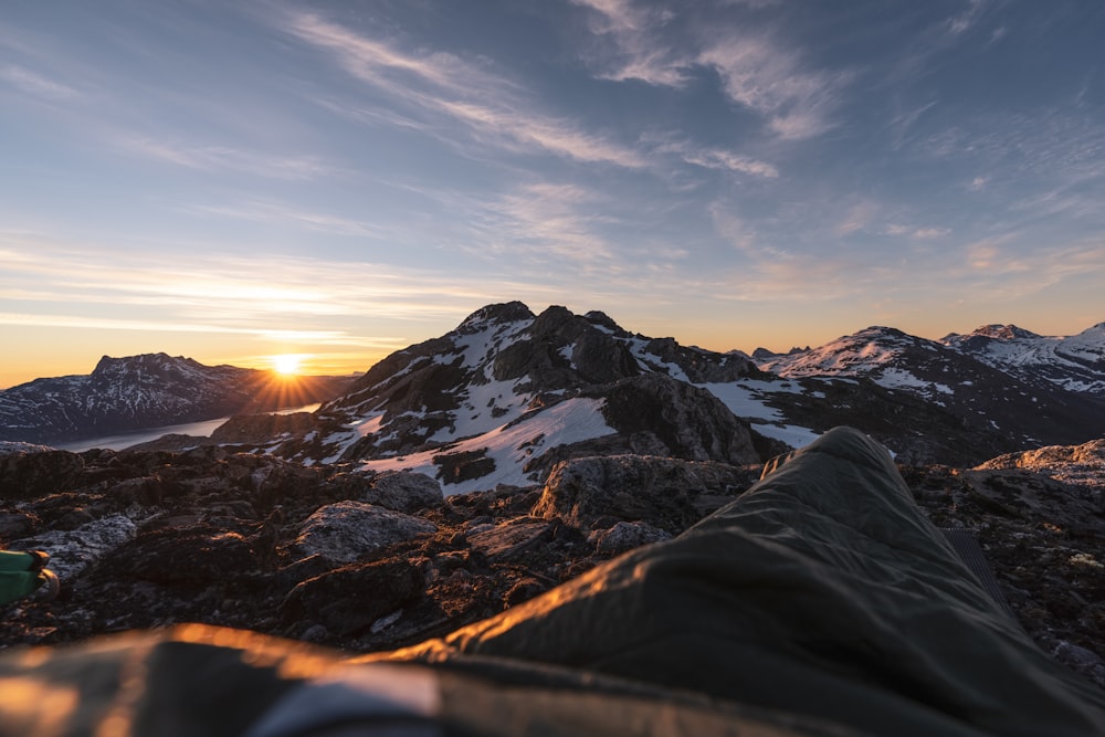 the sun is setting over a mountain range