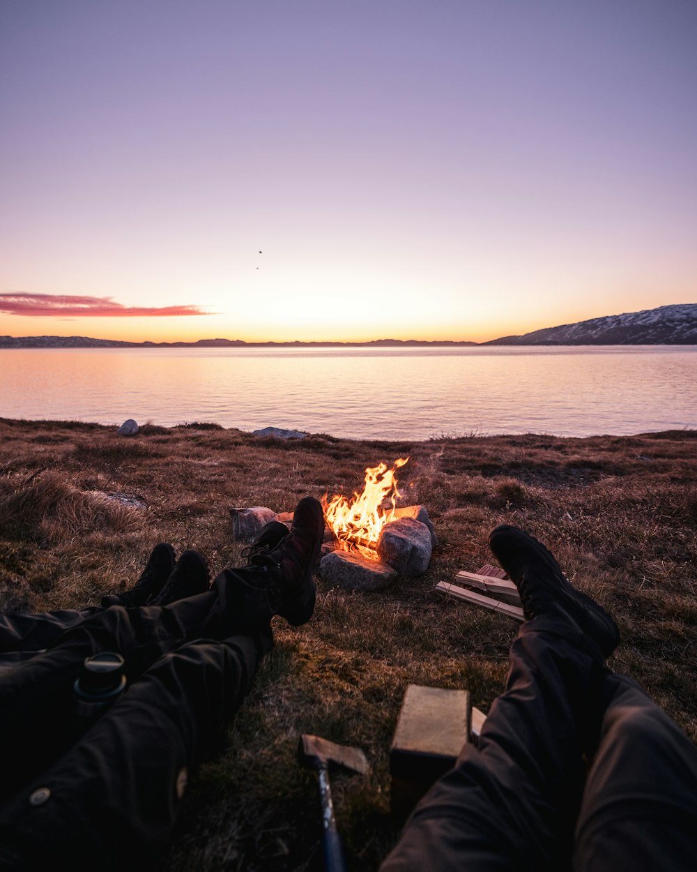 a person is sitting in front of a campfire