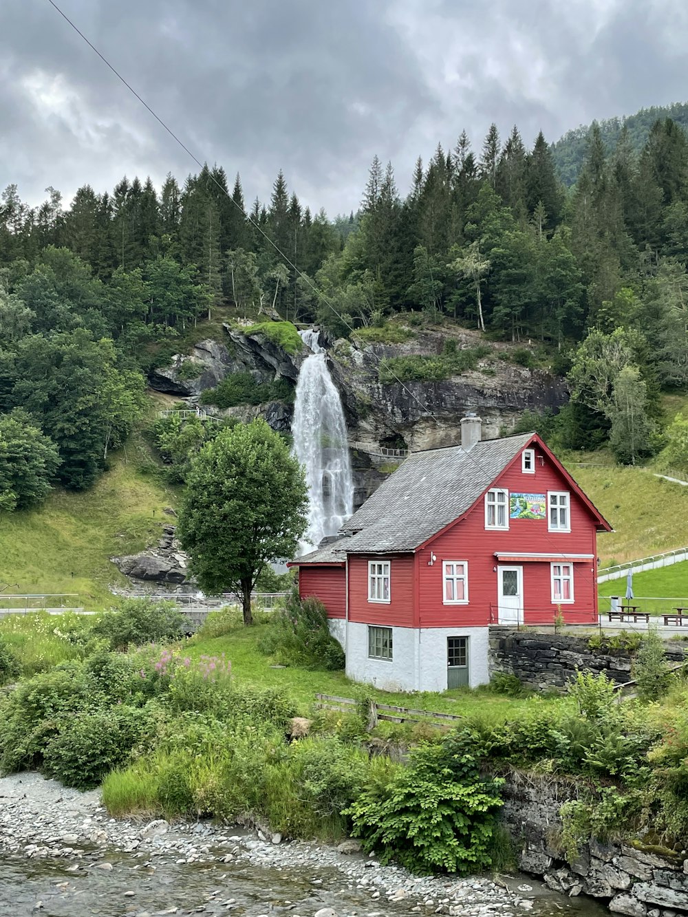 a red house with a waterfall in the background