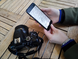 a person holding a cell phone over a camera
