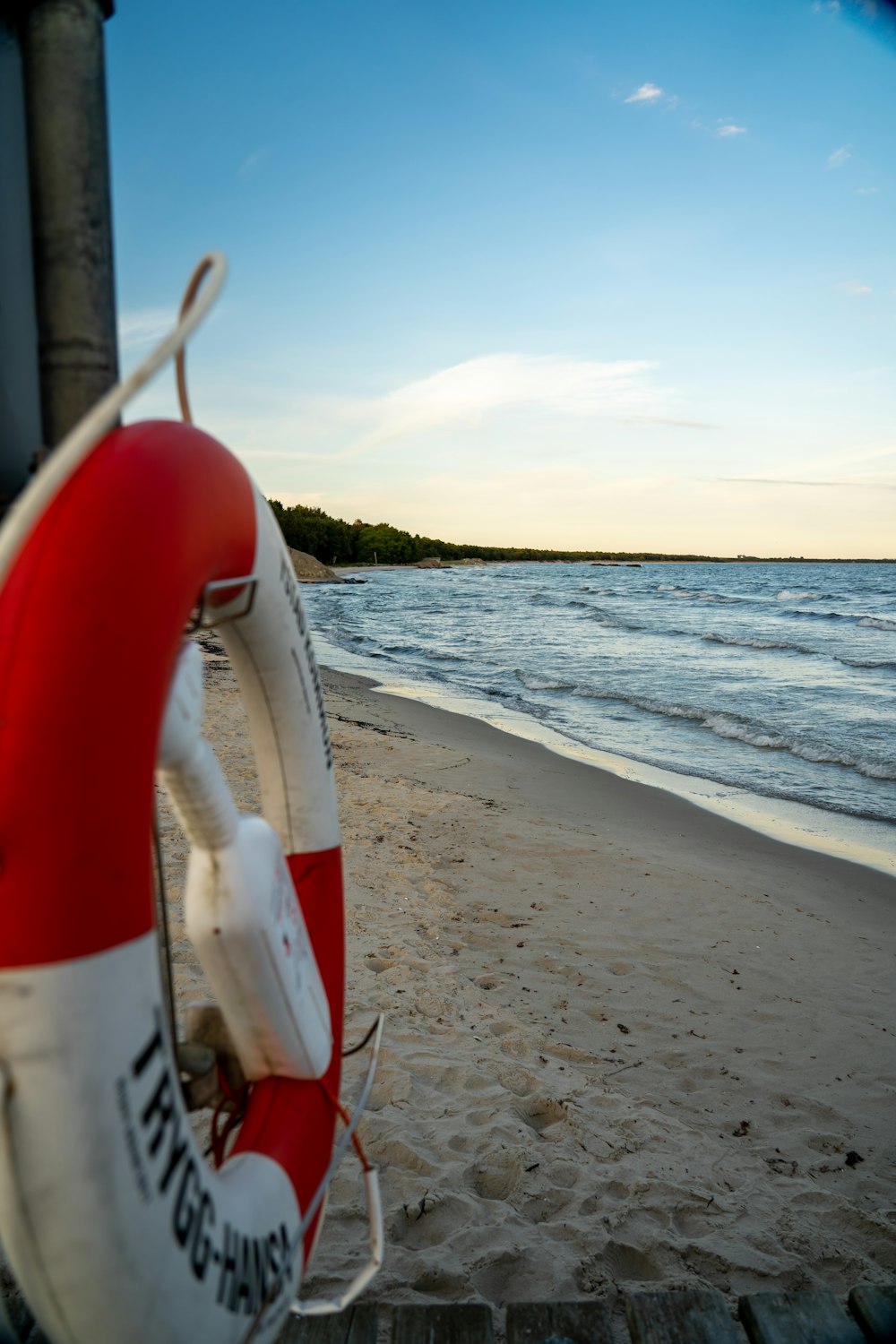 a life preserver sitting on the beach next to the ocean