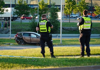 two police officers standing in front of a car