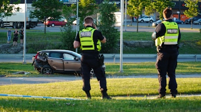 two police officers standing in front of a car
